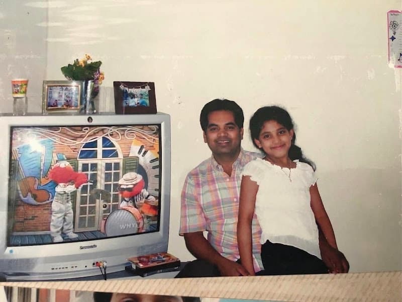 Sony as a girl on her first day of school in America, beside her dad